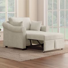 a living room scene with focus on the chair and ottoman that's under the window