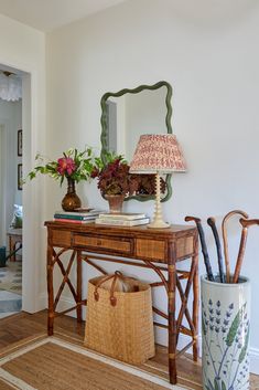 a wooden table topped with a lamp next to a mirror