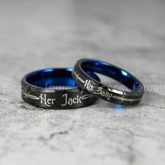 two blue wedding rings with the words her and him engraved on them