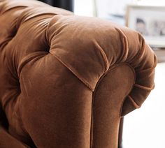 the back end of a brown couch in a living room