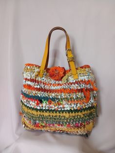 a multicolored handbag hanging on a white wall