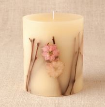 a white candle with pink flowers on it