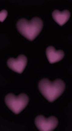 many pink hearts are arranged in the shape of heart shapes on a black background with blurry edges