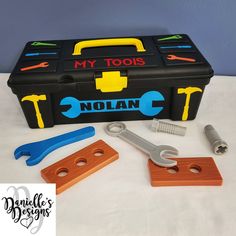 a toolbox with tools and wrenches on it sitting on a table next to a screwdriver