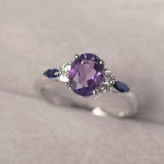 * The delicate ring displays Amethyst as main stone. The cluster side stones make the ring similar to the blooming flower . For who wearing this special & delicate ring, will shine like a goddess. ◆ Production Description: Main stone Type: Amethyst Main Stone Shape: Oval Cut Main Stone Size: 6*8mm (1.14ct) Side stone: CZ & lab sapphire Metal: 925 Sterling silver - Other options available in the drop down menu ◆ Customization: √Free for Add Engraving √Other Metal Type Available √Other Gem Classic Wedding Amethyst Ring With Gemstone Accents, Classic Sapphire Rings In Purple, Delicate Sapphire Gemstone Ring For Anniversary, Oval Purple Diamond Ring With Gemstone Accents, Oval Birthstone Promise Ring With Gemstone, Delicate Sapphire Ring For Anniversary, Delicate Amethyst Gemstone Ring For Anniversary, Oval Crystal Promise Ring With Accent Stones, Delicate Rings With Accent Stones In Round Cut