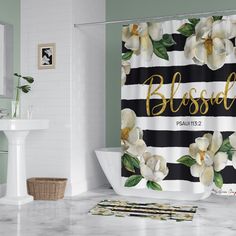 a white and black striped shower curtain with flowers on it that says, blessed in gold lettering