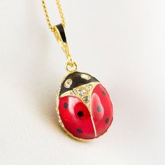 "Enameled and 24 K gold plated over solid sterling silver, ladybug egg pendant created in the famous tradition of Faberge jewelry in our NJ shop.   As kids , we would hold a ladybug in an open palm and sing something like that:  Ladybug, ladybug, fly in to the sky, bring us some bread, any kind, just make sure that it is not burned.    The pendant is about 0.7\" long not including the bail for a chain.  Clear crystals are set in the eyes and in the neck of the bug on both sides of the egg.  Well Yellow Gold Enamel Oval Pendant Necklaces, Gold Enamel Necklaces With Cabochon, Gold Enamel Necklace With Cabochon, Black Enamel Oval Necklace As Gift, Black Enamel Oval Necklace For Gift, Oval Enamel Necklace For Gift, Oval Black Enamel Jewelry Gift, Yellow Gold Necklaces With Black Enamel For Gift, Oval Enamel Jewelry For Gift