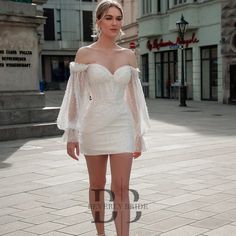 a woman in a short white dress standing on the street