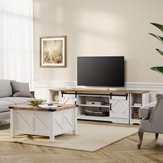 a living room with couches and a television on top of a wooden coffee table