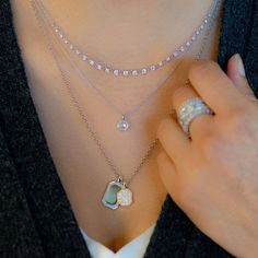 a woman wearing three different necklaces on her chest and one with a heart shaped pendant