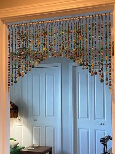 an open door with beads hanging from it's sides and a table in front of it