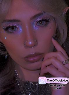 a woman with glitter on her face and nose is posing in front of the camera