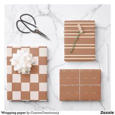 wrapping paper by custom creations is displayed on a marble surface with scissors and other items