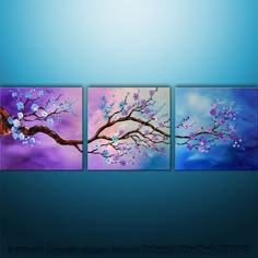 three pieces of art on a wall with blue and purple colors, one has a tree branch