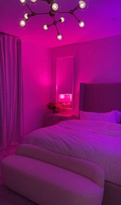 a bedroom with purple lighting and a bed in the middle is lit up by pink lights