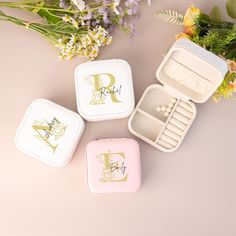 three personalized jewelry boxes with flowers in the background