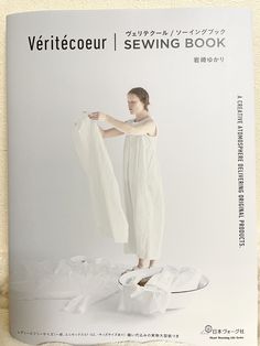 the front cover of a sewing book with a woman in white clothing holding up a piece of cloth