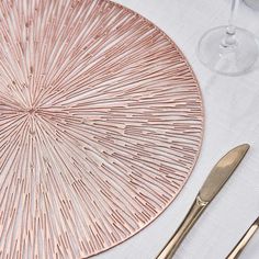 a place setting with silverware and rose gold flatware on a white table cloth