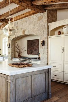 a kitchen with an island in the middle of it and stone walls on both sides