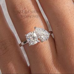 a woman's engagement ring with two pear shaped diamonds