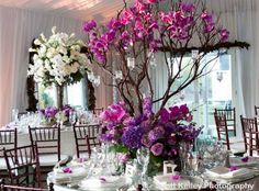 the table is set with purple and white flowers