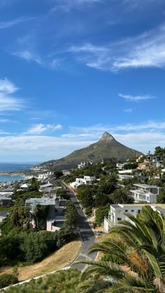 an aerial view of a city with mountains in the background and palm trees on the foreground