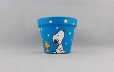 a blue plastic cup with a snoopy dog on it's side and stars in the background