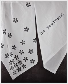 two white tea towels with black flowers on them that say be yourself and the words'be yourself '