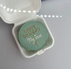 a green cake in a white box with the words happy birthday my love written on it