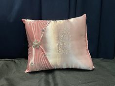 a pink and gold pillow on a bed