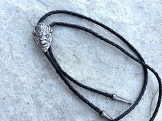 This awesome bolo tie has a metal buffalo head. The cord is genuine leather. Our bolos pair nicely with many of our belt buckles! They make wonderful gifts. The western bolo tie rope length is 100cm(39") ; pendant size is 1 1/2'' x 1 1/4'' Adjustable Black Bolo Tie For Rodeo, Adjustable Black Bolo Ties For Rodeo, Black Adjustable Bolo Ties For Rodeo, Black Southwestern Jewelry For Rodeo, Southwestern Black Jewelry For Rodeo, Black Engraved Western Jewelry, Black Western Bolo Tie With Concho, Black Concho Jewelry For Rodeo, Black Western Bolo Tie With Adjustable Length