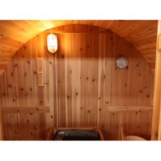 the inside of a sauna with wood paneling and a clock on the wall