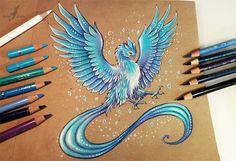 a drawing of a blue bird with its wings spread out, surrounded by colored pencils