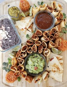 an assortment of mexican food on a platter with salsa and guacamole