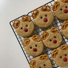 cookies with pretzels and reindeer noses are on a cooling rack, ready to be eaten