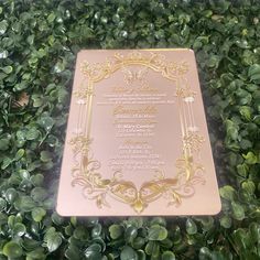 a pink plaque sitting on top of a lush green hedge covered in gold leafy foliage