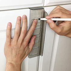 a person is holding a pencil in front of a door handle