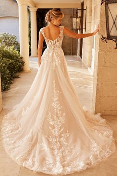 a woman in a wedding dress is standing on the porch with her back to the camera