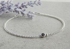 "This sterling silver personalized anklet for women is the perfect gift idea for anyone or even for yourself!  This 925 silver ankle bracelet is beaded with 2.5 mm sterling silver round beads.  The letter bead is made of rhodium plated pewter.  I have added a crystal on each side of the letter bead for that little bit of sparkle! Pick your letter in the drop down menu. Anklet measures a little over 9\" and has a 1\" sterling silver extender giving you up to 10\" if needed. It is finished with a Personalized Silver Dainty Beaded Bracelets, Personalized Silver Anklets, Silver Beaded Anklets As Gift, Silver Beaded Anklets For Gift, Silver Beaded Name Bracelet For Gift, Silver Beaded Name Bracelet Gift, Personalized Adjustable Silver Anklets, Minimalist Anklets With Round Beads For Gift, Minimalist Round Bead Anklets As Gift