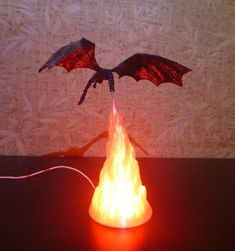 a dragon sculpture is lit up on a table with a red light in front of it