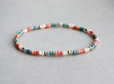 a beaded bracelet with multicolored beads on a white surface, close up