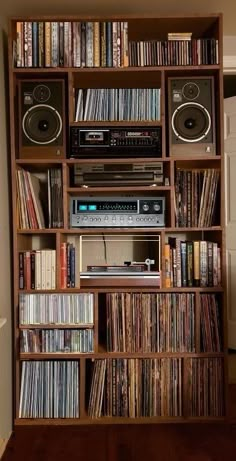 a bookshelf filled with lots of different types of audio equipment and music cassettes