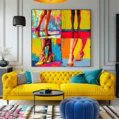 a living room with yellow couches and colorful paintings on the wall