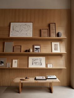 a wooden shelf filled with books and pictures on it's side wall next to a coffee table