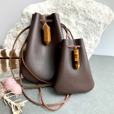 "Vegan Eco Leather Medicine Bag, Shaman Bag or Amulet Pouch to wear around your neck-or hang in your Car! Perfect for Ceremony or for Festival Wear. Dark Chocolate Faux Leather with a Tiger Eye Healing Stone Point. The Large size has a Double Terminated Stone! Unique and Beautiful Gift . A place for things that have Spiritual Meaning for you-like that pretty rock your 3 year old gave you.... Two Choices: Small:3 3/4\"deep 2 3/4\"wide Large:5 1/4\"deep 4\"wide BUY ANY 4 MEDICINE BAGS(VEGAN LEATHE Rectangular Faux Leather Bags With Card Slots, Rectangular Faux Leather Bag With Card Slots, Leather Shoulder Bag Pouch, Portable Leather Shoulder Pouch, Faux Leather Pouch Bag, Brown Crossbody Pouch With Dust Bag, Leather Shoulder Bag As Gift, Leather Coin Purse In Pouch Shape, Portable Pouch Shoulder Bag As Gift