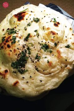 a close up of a plate of food with cheese and herbs on it's surface