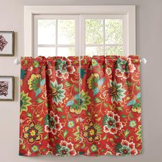 a red floral curtain hanging on the side of a window