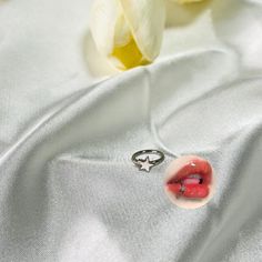 a close up of a ring on a white shirt with a flower in the background