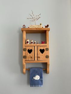 a wooden shelf with two drawers and a towel on the wall next to a blue towel