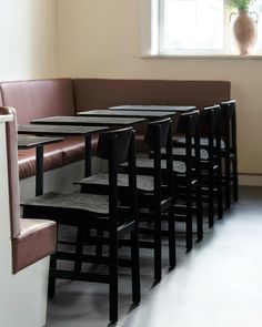 a row of black tables sitting next to each other on top of a white floor